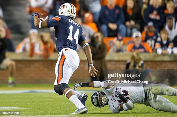 Defensive back Christian Milstead of the Florida Atlantic Owls attempts to tackle quarterback Nick Marshall of the Auburn Tigers on October 26, 2013...