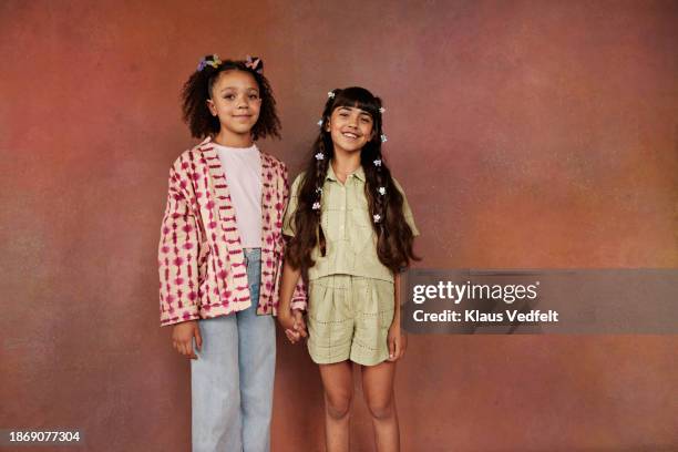 smiling girls holding hands while standing together - iranian people stock pictures, royalty-free photos & images