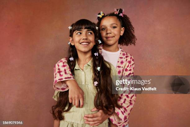smiling girl embracing friend from behind - haarspange stock-fotos und bilder