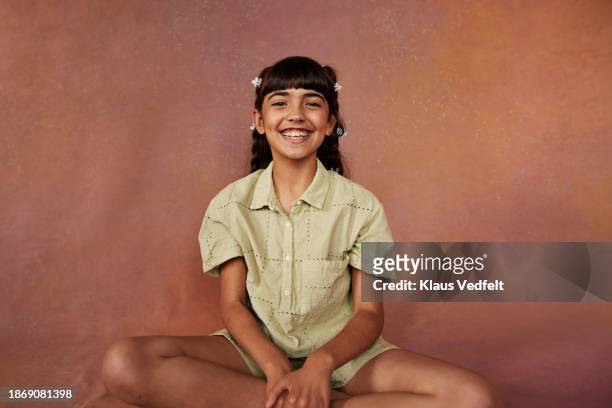 happy girl sitting cross-legged with bangs - iranian people stock pictures, royalty-free photos & images