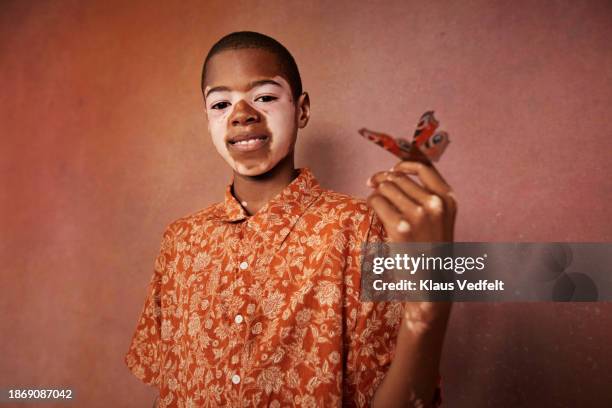 smiling boy with vitiligo and butterfly on finger - budding tween stock pictures, royalty-free photos & images