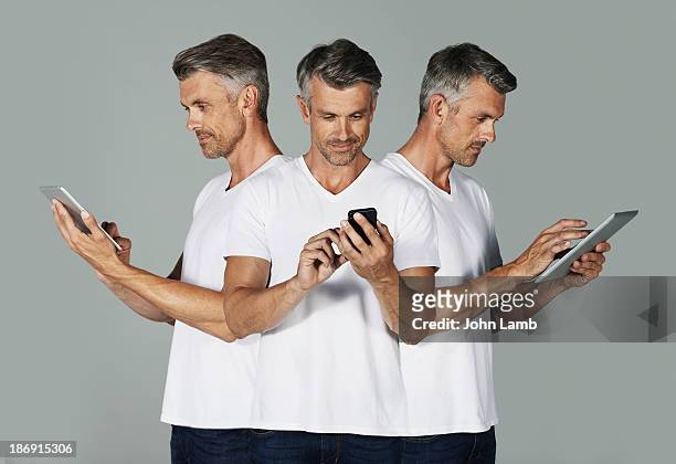 social devices - mature man using phone tablet stock pictures, royalty-free photos & images