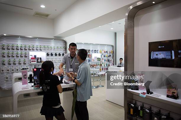 An HTC Corp. Employee assists a customer at one of the company's stores in Taipei, Taiwan, on Monday, Nov. 4, 2013. Taiwans five-year bonds gained...