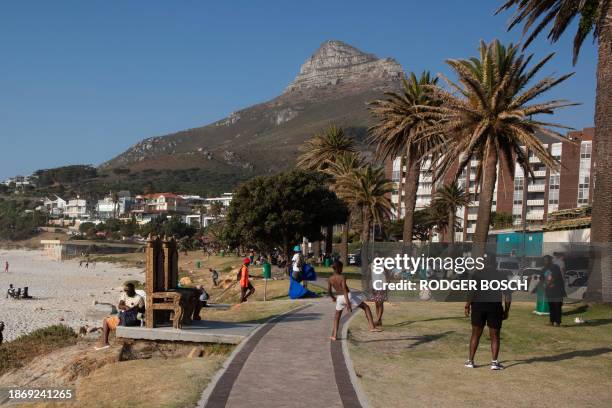 People enjoy themselves on a hot day at Camps Bay beach, near Cape Town, on December 22, 2023.