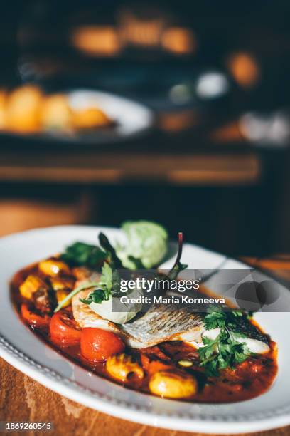 grilled sea-bass served with tomato sauce and grilled vegetables. - sea bass stock pictures, royalty-free photos & images