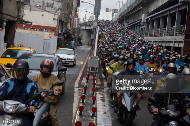 Motorists on motorcycles sit in traffic along a bridge in Taipei, Taiwan, on Monday, Nov. 4, 2013. Taiwans five-year bonds gained for the first time...