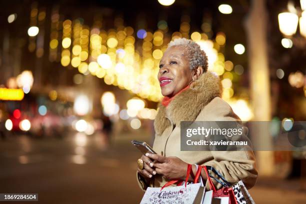 waiting for a taxi after christmas shopping - black coat stockfoto's en -beelden