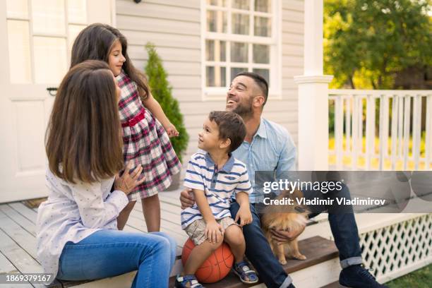 a family of four on the front porch - home sweet home dog stock pictures, royalty-free photos & images