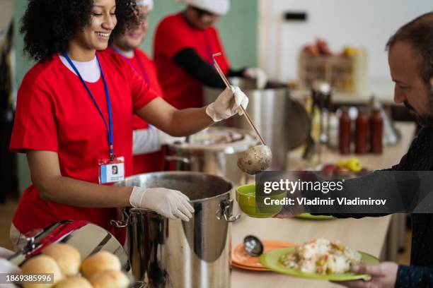 happy volunteers serving food at christmas - homeless winter stock pictures, royalty-free photos & images