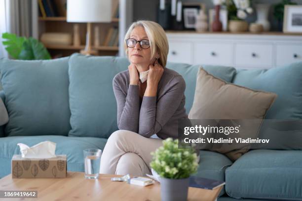 thoughtful woman sitting on couch - seasonal affective disorder stock pictures, royalty-free photos & images