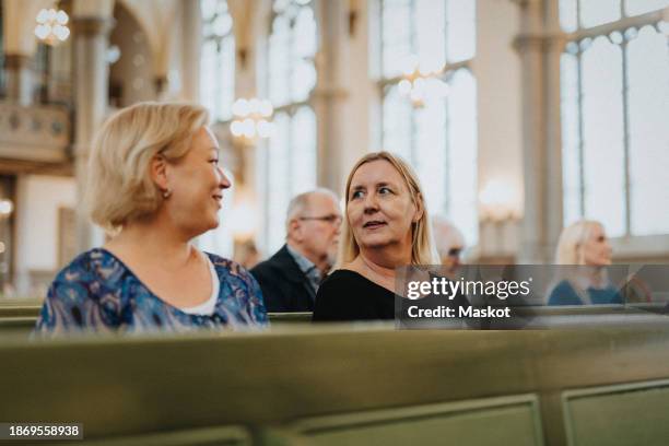 mature women talking with each other while sitting at protestant church - banco de igreja imagens e fotografias de stock