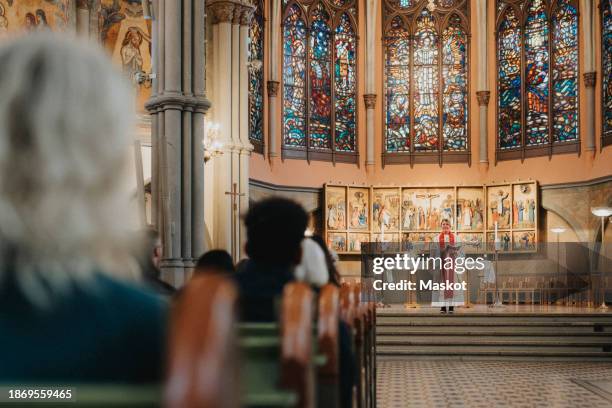 female priest giving sermon while standing near altar at protestant church - priest stockfoto's en -beelden