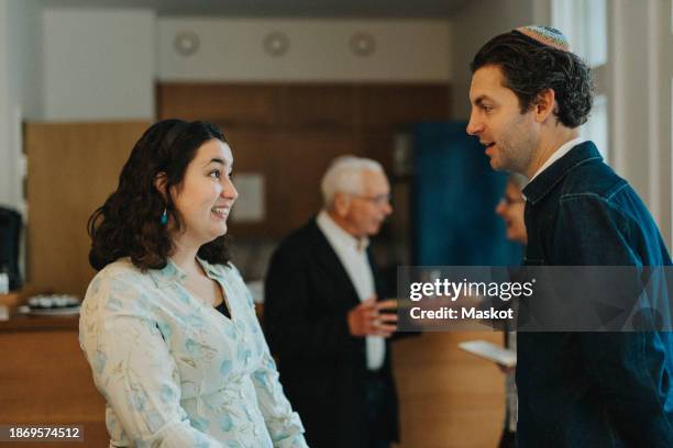 jewish man and woman talking with each other at synagogue - jewish people stock-fotos und bilder