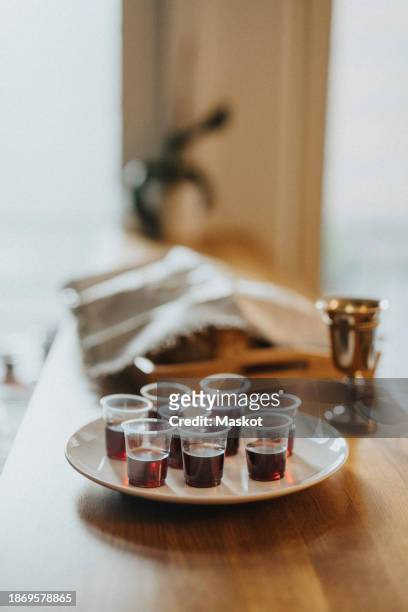 wine glasses arranged in plate on table at synagogue - kiddush cup stock-fotos und bilder