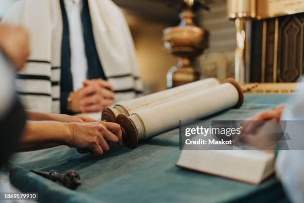 hands of senior woman opening torah script at synagogue - reading synagogue stock pictures, royalty-free photos & images