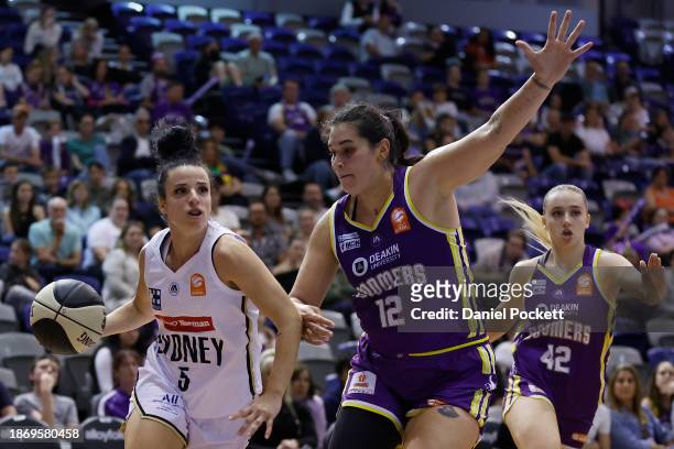 Vanessa Panousis of the Flames drives to the basket under pressure from Penina Davidson of the Boomers during the WNBL match between Melbourne...