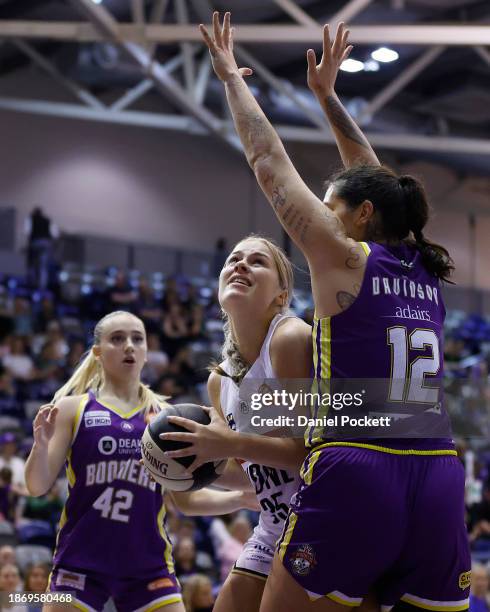 Isla Juffermans of the Flames shoots under pressure from Penina Davidson of the Boomers during the WNBL match between Melbourne Boomers and Sydney...