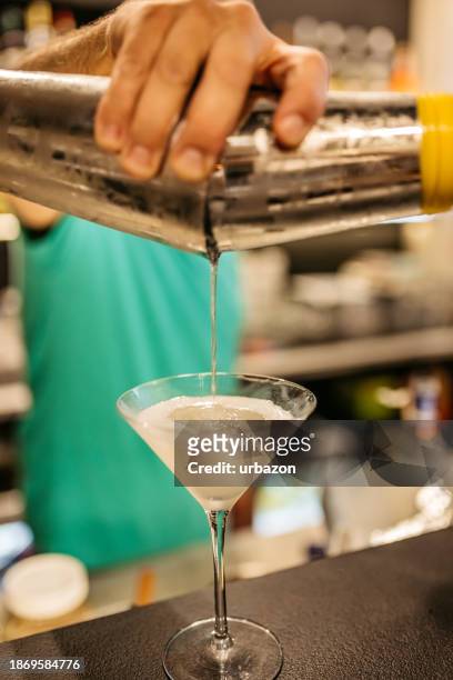 mid-adult bartender making an apple martini on the bar counter - apple night club stock pictures, royalty-free photos & images