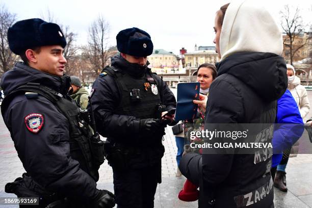 Police officers check documents of relatives of Russian soldiers, taking part in the so-called "special military operation" in Ukraine, as they...