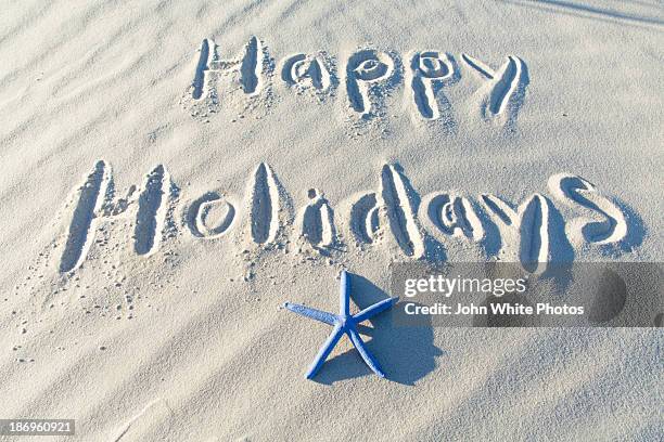 happy holidays written on a beach. - happy holidays around the world stock pictures, royalty-free photos & images