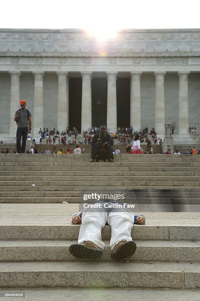Tourist Rests in front of the Lincoln Memorial
