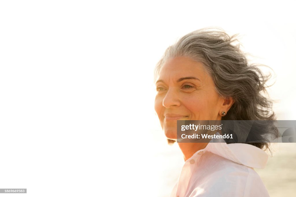 Smiling mature woman with gray hair at beach