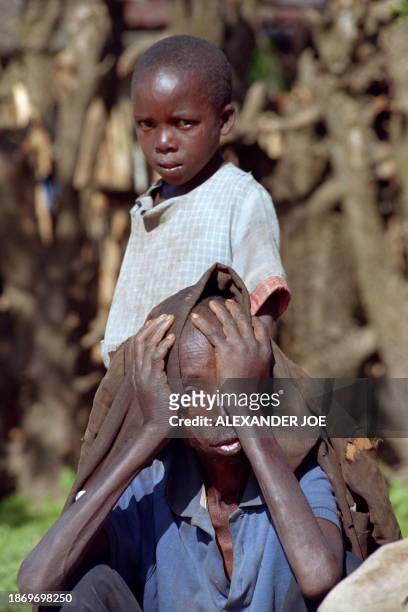 Rwandan displaced father ad his son rest on May 29, 1994 on the side of the road after walking for days from Kigali to Gitarama, about 40 kms, trying...