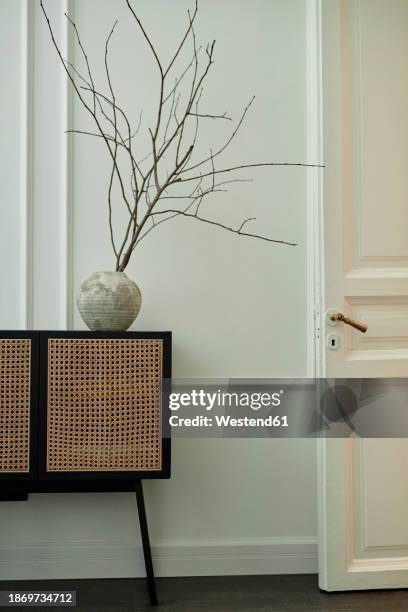 part of living room interior with vase on sideboard - anrichte stock-fotos und bilder
