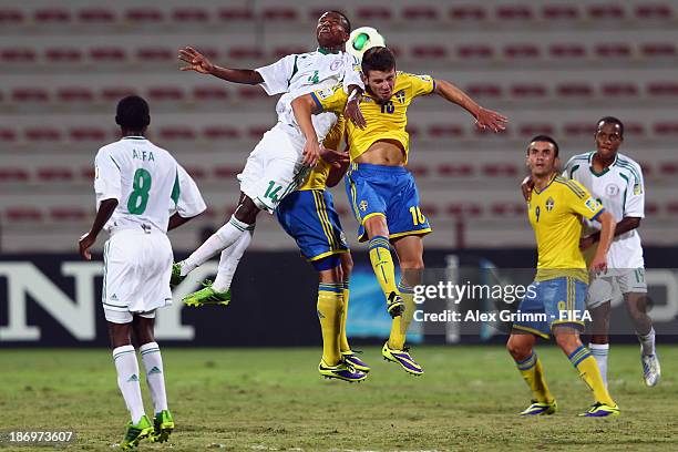 Chidiebere Nwakali of Nigeria jumps for a header with Erdal Rakip of Sweden during the FIFA U-17 World Cup UAE 2013 Semi Final match between Sweden...