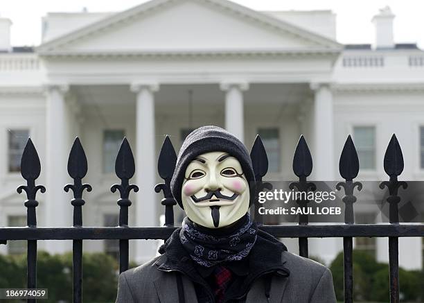 Demonstrator, including supporters of the group Anonymous, poses during a march in protest against corrupt governments and corporations in front of...