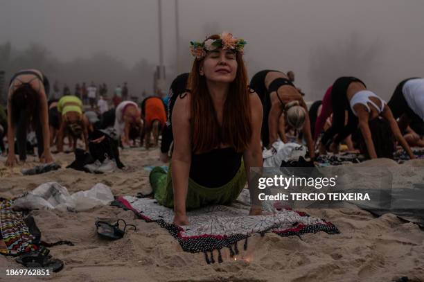People attend a massive yoga class during the "Yoga ao Sol Nascer" event, at Recreio dos Bandeirantes beach in Rio de Janeiro, Brazil, on December...