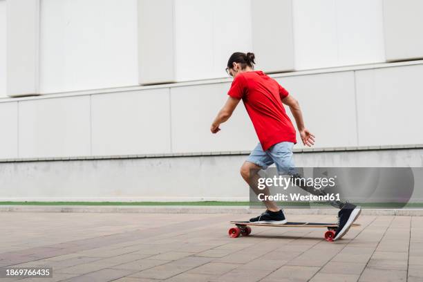 young man with prosthetic leg riding skateboard at footpath - artificial limb stock pictures, royalty-free photos & images
