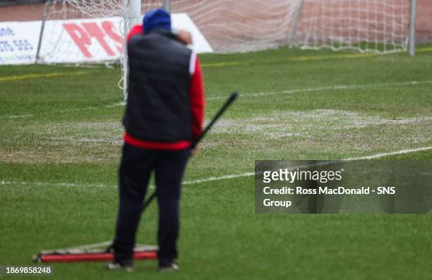 Dundee Groundsmen clear the water on the pitch before a pitch inspection before a cinch Premiership match between Dundee and Aberdeen at the Scot...