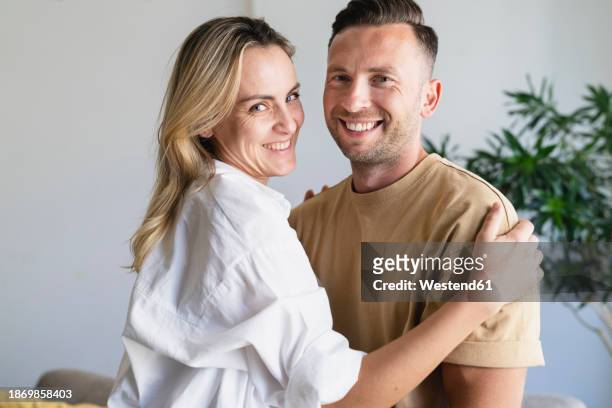 happy man and woman standing together at home - ic foto e immagini stock