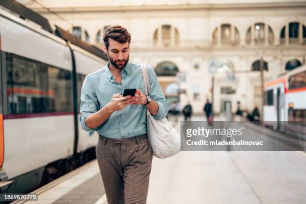 junger selbstbewusster geschäftsmann an der u-bahn-station - business man texting stock-fotos und bilder