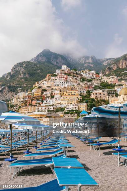 italy, campania, positano, empty deck chairs on amalfi coast beach - beach town stock pictures, royalty-free photos & images