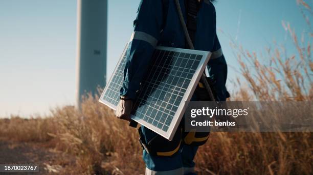 close-up of african female engineer's hands surveying alternative energy in windmill fields with solar cell equipment for sustainable energy research. - con eficaz consumo de energía fotografías e imágenes de stock