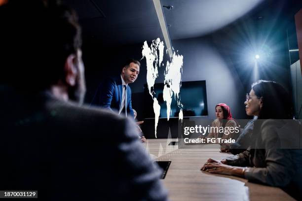 hombre de negocios usando holograma durante una reunión en la oficina - holographic-map fotografías e imágenes de stock