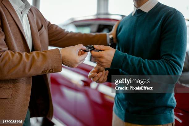 cardealer giving car key to customer - car display background stock pictures, royalty-free photos & images