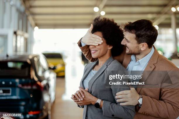 covering his wife's eyes to surprise her with new car - new girlfriend stock pictures, royalty-free photos & images