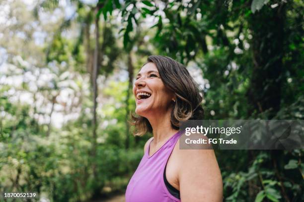 mature woman looking around on the public park - body image stock pictures, royalty-free photos & images