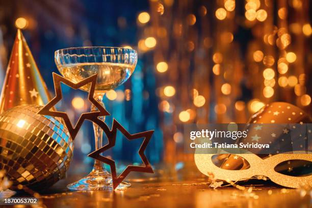 new year celebration concept with golden lights and masquerade masque - máscara-para-fiestas fotografías e imágenes de stock