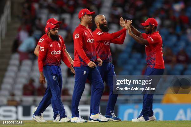 Moeen Ali of England celebrates with teammates after getting the wicket of Brandon King of West Indies during the 4th T20 International match between...