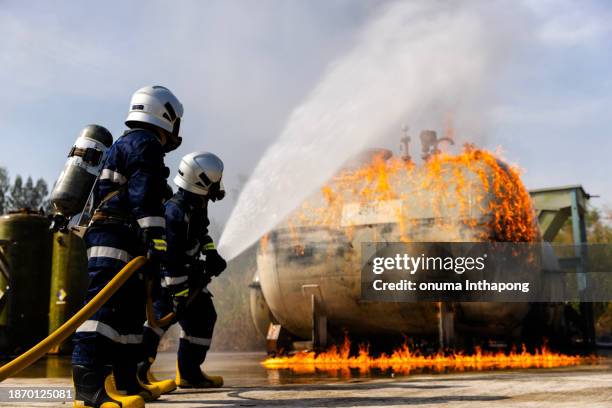 firefighters safety using twirl water fog type fire extinguisher to fighting with fire from oil - fire station stock pictures, royalty-free photos & images