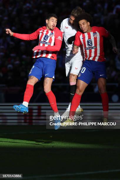 Sevilla's Spanish defender Sergio Ramos vies with Atletico Madrid's Uruguayan defender Jose Gimenez and Atletico Madrid's Belgian midfielder Axel...