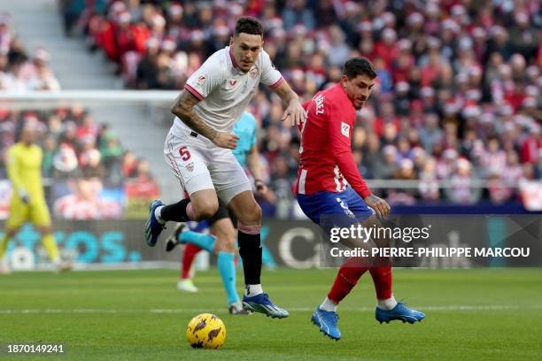 Sevilla's Argentinian forward Lucas Ocampos vies with Atletico Madrid's Uruguayan defender Jose Gimenez during the Spanish league football match...