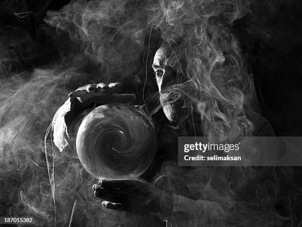 fortune teller in fantastical costume holding crystal ball - magier stockfoto's en -beelden