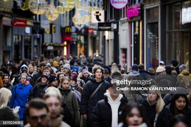 Shoppers walk in a street with shops, in the centre of Amsterdam on December 23, 2023. / Netherlands OUT