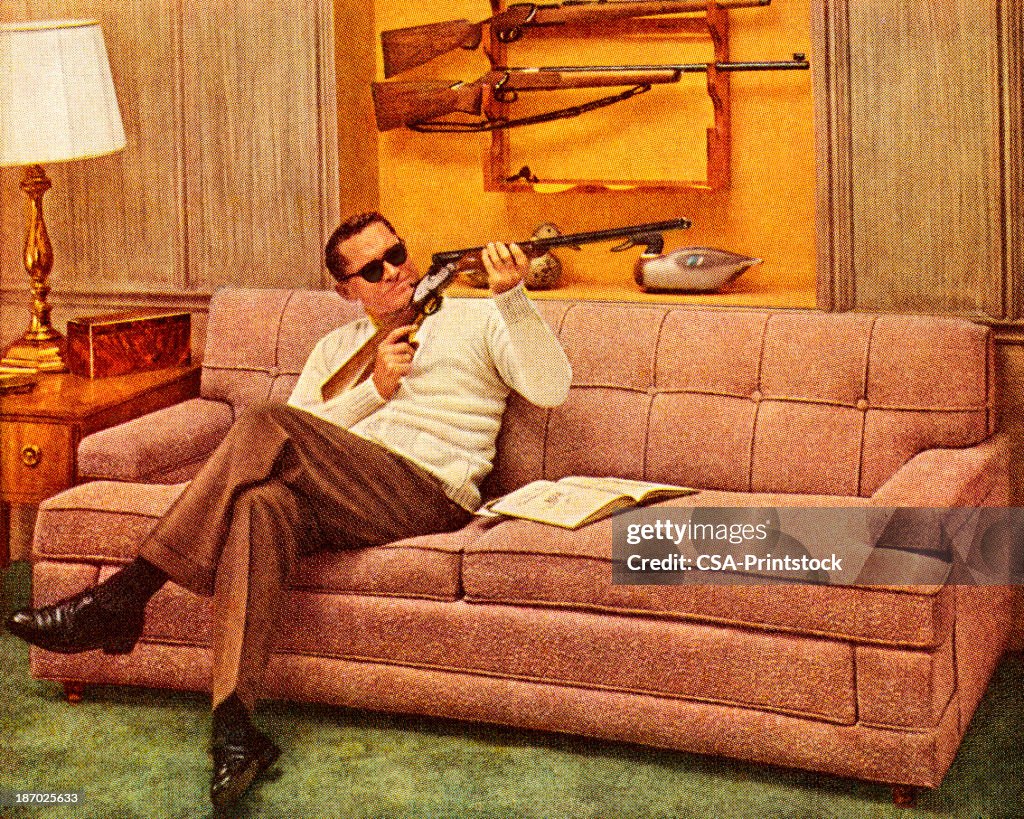 Man Wearing Sunglasses and Holding Gun
