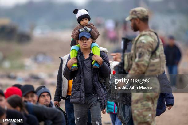 Texas National Guard soldier counts a group of immigrants who had crossed the U.S.-Mexico border on December 20, 2023 in Eagle Pass, Texas. A...